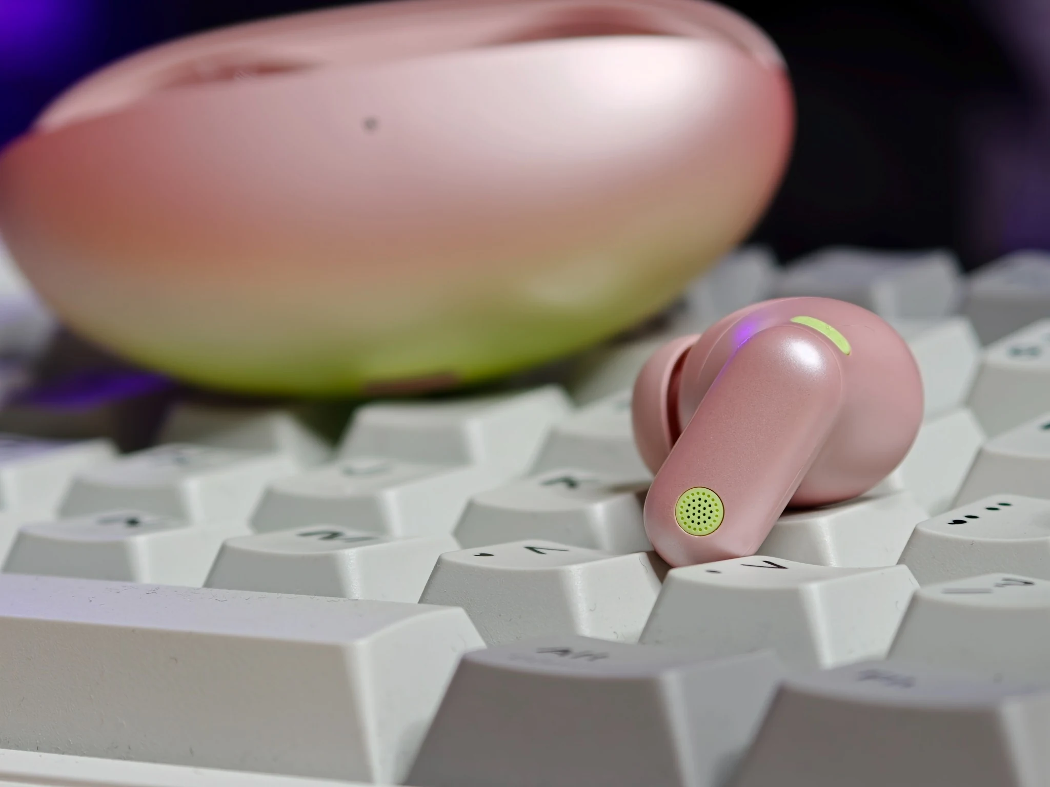 Auricolare HUAWEI FreeBuds Neo Rosa Nebulosa su una tastiera bianca