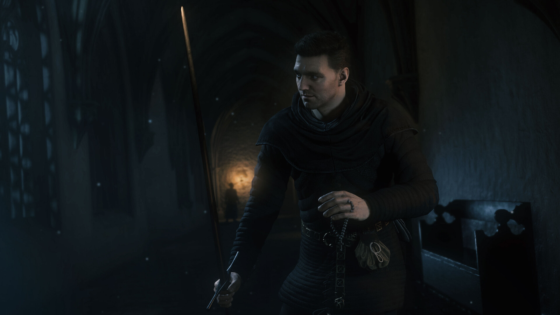 Henry si muove in un ambiente buio del monastero — Kingdom Come: Deliverance II.